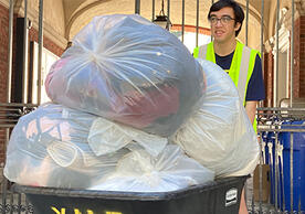 Spring Salvage student worker Xander Calictan ’25 wheels a cart of clothes during student move-out